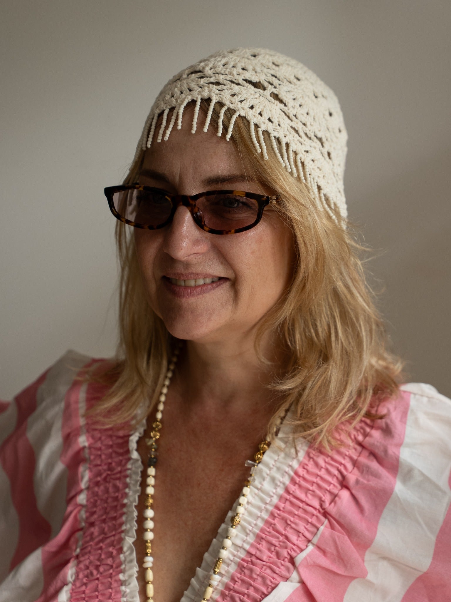 Bonnet Diego porté, en crochet crème avec franges perlées