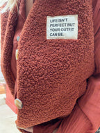 Détail du gilet bouclette Zoé rouille et de son étiquette