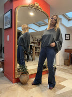 Pull asymétrique Annaëlle gris foncé 100 % coton — vue de trois quarts avec le jean Tiffany