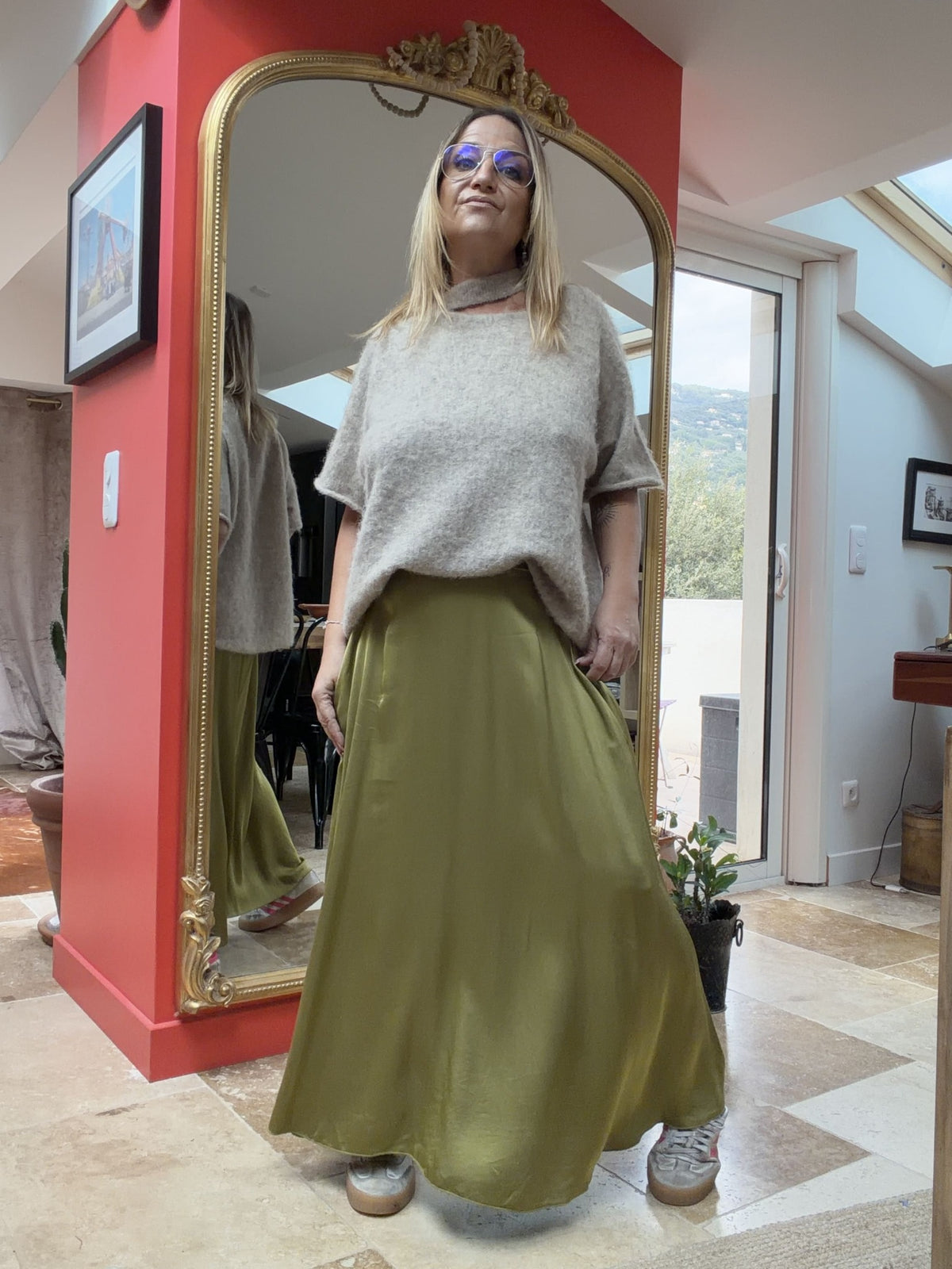 Pull asymétrique Émilie beige porté avec une jupe kaki, vue de face